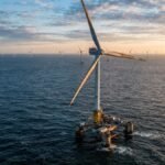 Floating wind turbines in a professional industrial offshore wind farm capturing marine energy at golden hour.